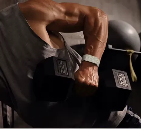 An athlete lifts a dumbbell wearing the band